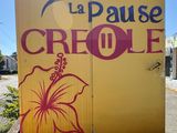 a sign that says la pause creole on the side of a building