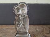 statue of a woman holding a child on a wooden table