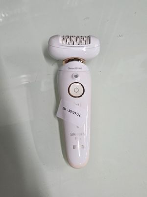 a close up of a white electric shaver on a white surface