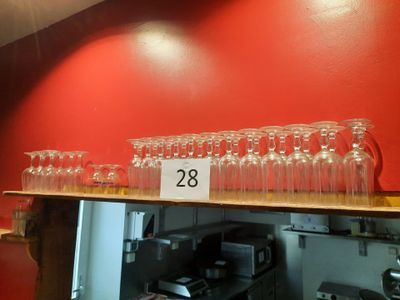 de nombreux verres à vin vides posés sur une étagère dans la cuisine