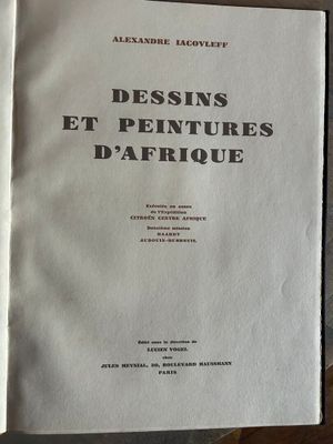 un livre ouvert posé sur une table en bois, à côté d'une tasse de café
