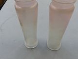 two glasses sitting on a table next to each other