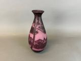 a vase with a pink and black design sitting on a table