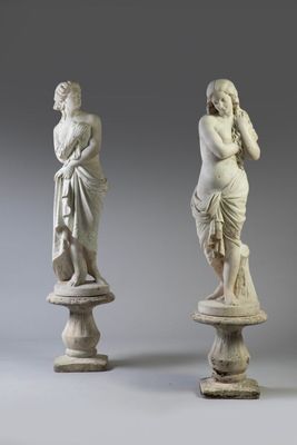 deux statues représentant un homme et une femme, posées sur des socles
