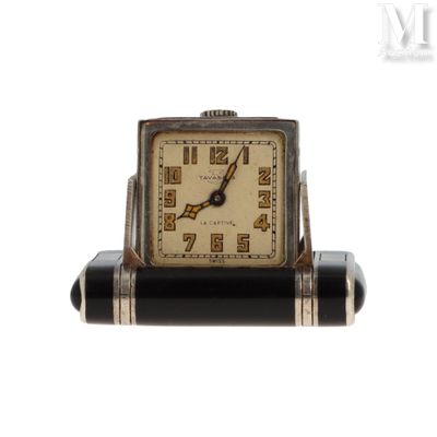 une image représentant une petite horloge en noir et blanc posée sur un socle