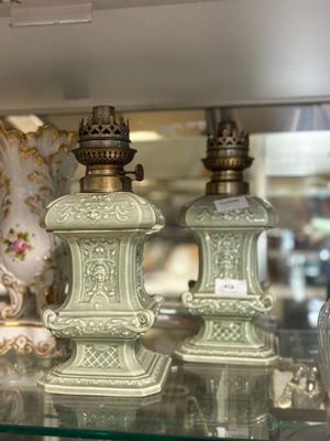 two green vases sitting on a glass shelf in a store