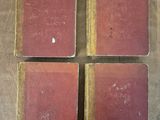 four old books sitting on top of a wooden table