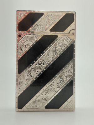 un vieux briquet en argent orné de rayures noires et blanches