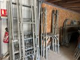 de nombreuses chaises et échelles empilées dans un garage
