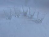 six glasses sitting on a table with a white background