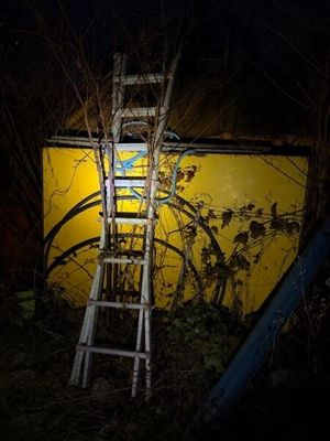 une échelle appuyée contre un mur jaune dans l'obscurité