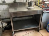 une table en acier inoxydable sur laquelle est posée une casserole dans une cuisine