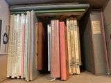 de nombreux livres qui sont rangés dans une boîte sur une étagère