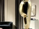 a statue of a bird on a pedestal in a living room