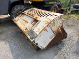 un objet métallique rouillé posé par terre à côté d'un camion