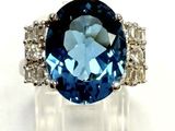 gros plan d'une bague avec une pierre bleue entourée de diamants