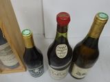 three bottles of wine sit in front of a wooden case