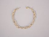 a close up of a gold chain bracelet on a white surface