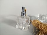 a small bottle of perfume sitting next to a small glass bottle