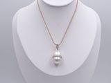 un pendentif composé d'une perle blanche et de diamants, monté sur une chaîne en or