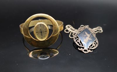 une bague en or sertie d'une pierre, à côté d'une autre bague en or sertie d'une pierre