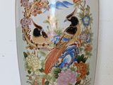 a large vase with a bird and flowers on it