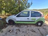 a small white car that is parked on the side of the road