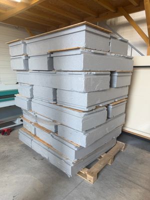 a stack of pizza boxes on a pallet in a garage