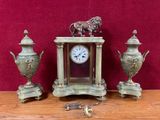 une photo représentant une horloge et trois vases posés sur une table