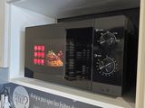a microwave that is sitting on a shelf in a kitchen