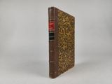 un vieux livre à la couverture brune posé sur une surface blanche