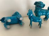 three figurines of animals on a white surface