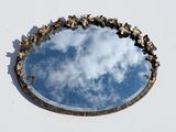 a round mirror with a sky reflection in it