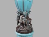 un vase bleu surmonté d'une statuette