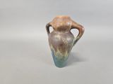 a brown and blue vase sitting on a white surface