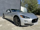 a silver sports car parked in front of a building