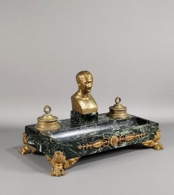 une statue représentant un homme assis sur un bureau en marbre