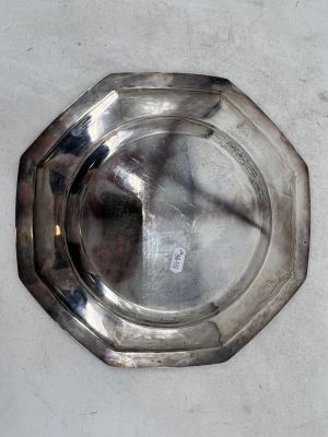 un cendrier en argent posé sur une table, sur fond blanc