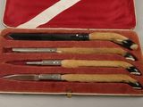 four different types of pens in a red case
