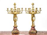 une paire de chandeliers anciens en laiton et marbre posés sur une table en marbre