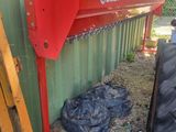 a red machine that is sitting next to a green building