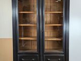 an antique black bookcase with glass doors in a living room