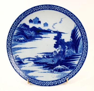 a blue and white plate with a landscape on it