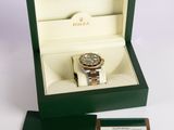 the rolex watch is in a green box with a card in it