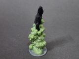 a figurine of a black bird sitting on top of a pile of rocks