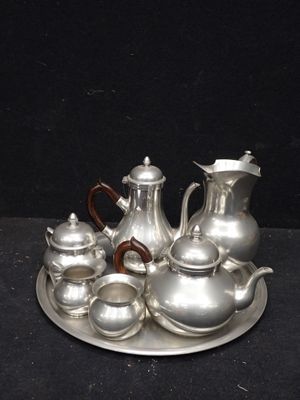 un plateau en argent sur lequel sont posées des théières et des tasses en argent
