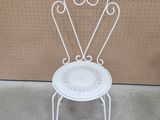 a white chair that is sitting in front of a wall