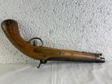 an old wooden gun with a metal handle on a table