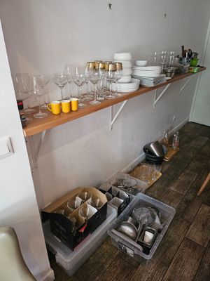 une cuisine avec beaucoup de vaisselle et de verres sur les étagères