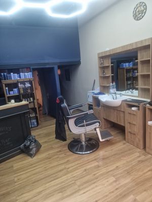 une photo d'un salon de coiffure avec un lavabo et un miroir